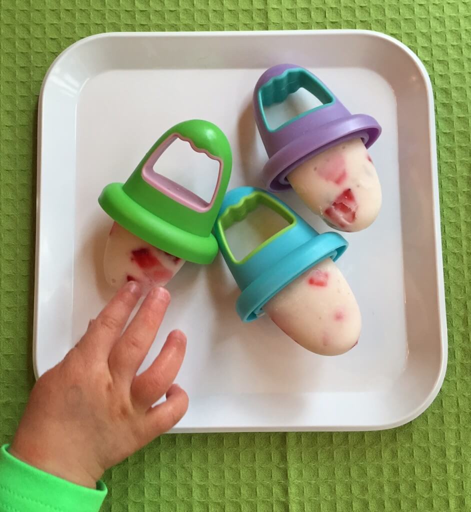 Frozen yogurt popsicles made with vanilla greek yogurt and fresh strawberries