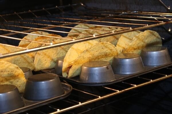 Make the crispiest oven baked tacos by flipping over your muffin pan--- and filling them with simple ingredients like lean ground beef and shredded cheese.