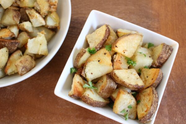 Whole garlic cloves and grated Parmesan cheese make these Garlic Roasted Potatoes a simple side dish the whole family will enjoy!