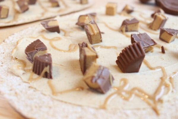 Peanut Butter Cup Pizza is the combination of two classic indulgences: peanut butter cups + pizza! Instead of a heavy crust, this sweet treat is made on Flatout Flatbread.