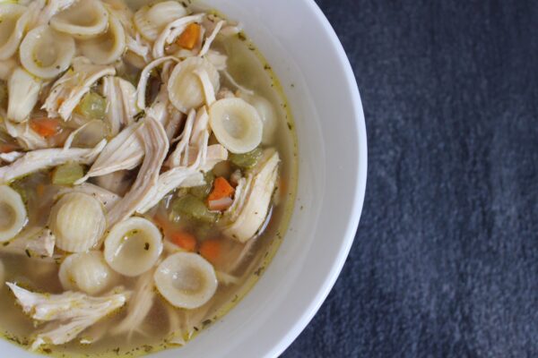roasted-garlic-chicken-noodle-soup - Mom to Mom Nutrition Roasted garlic chicken noodle soup in a white bowl.