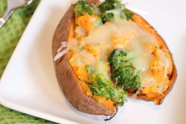 Stuffed sweet potatoes are filled and baked with veggies and cheese, making an easy weeknight meal or healthier side for Thanksgiving dinner.