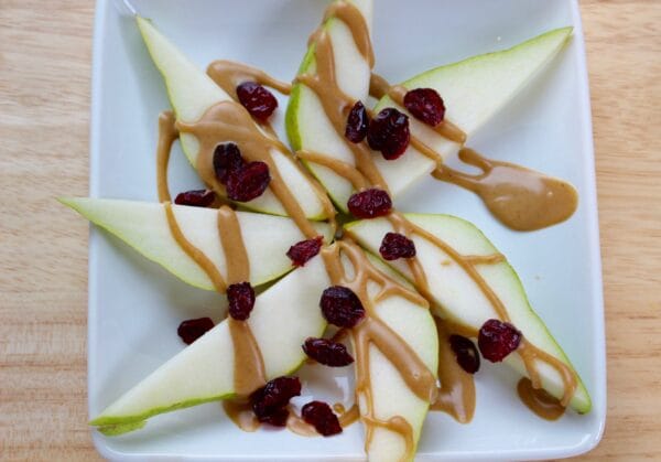 Easy to make pear nachos are a nutritious snack that will fuel any hungry tummy. Pear slices are simply topped with nut butter and dried cranberries.