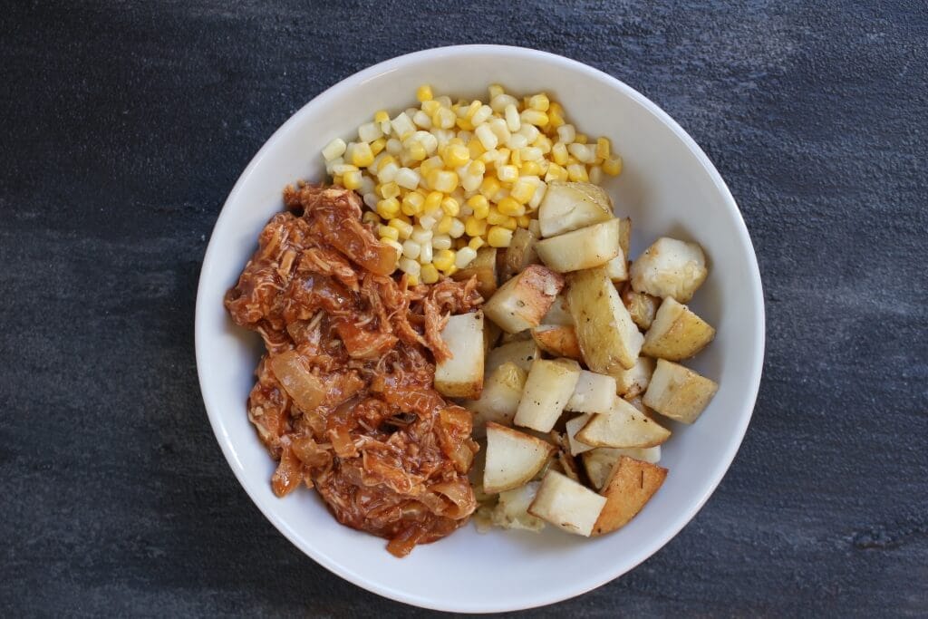 BBQ Chicken Bowls with slow cooked BBQ chicken, onions, roasted potatoes and corn make a simple make-ahead meal that are easily reheated for any busy weeknight.