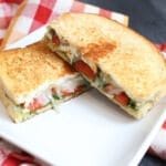A simple grilled cheese sandwich is packed with extra flavor from pesto and roasted red pepper inside, giving it a gourmet spin!