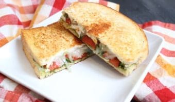 A simple grilled cheese sandwich is packed with extra flavor from pesto and roasted red pepper inside, giving it a gourmet spin!