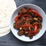 Tender steak and sweet bell peppers come together for one simple weeknight meal with these slow cooker steak fajitas!