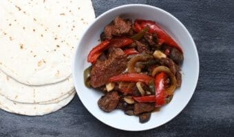 Tender steak and sweet bell peppers come together for one simple weeknight meal with these slow cooker steak fajitas!