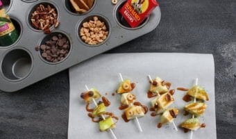 Caramel apple pops are an easy and delicious way to eat a traditional caramel apple. Get the kids involved in topping their own with dried cereal, chocolate chips, or extra caramel sauce!