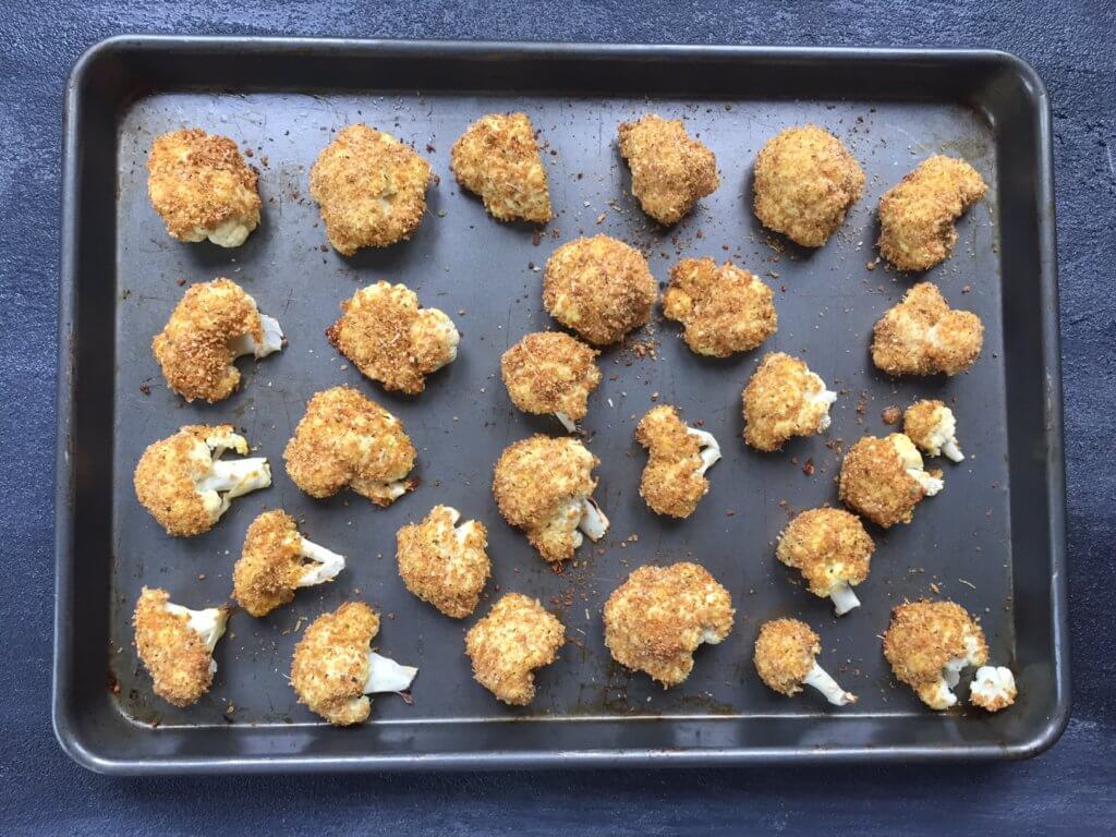 Baked parmesan cauliflower bites are breaded with a mixture of parmesan cheese and Italian seasoning, and served with marinara sauce for a perfect side dish or snack!