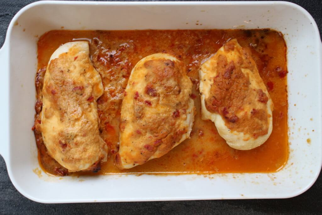 A simple chicken breast gets topped with creamy hummus for one weeknight meal that’s ready in no time! Sometimes I come up with a new meal idea and think to myself, “man, I still got it!” Just when I think my children have taken all my brain cells and zest for cooking with their hot dog and grilled cheese demands, I put two and two together like this hummus baked chicken and alas, mealtime is FUN again. Really though, whenever I serve chicken, steak, pork, etc. to the boys, I almost always serve it with hummus. Why? Because they dip almost anything in hummus. And I’m therefore almost guaranteed they’ll take a bit or two of the meat. So when my creative side decided it was time to TOP the chicken with hummus AND let the boys see what I was doing with their favorite spread [or dip], we were all pretty excited for the hummus baked chicken results! For this recipe I had Sabra Roasted Red Pepper hummus on hand so I decided to use that for the topping. Next time I think I’m going to try plain hummus + a tablespoon of dry ranch seasoning. Or maybe chipotle hummus + taco seasoning mix. Because there are so many flavors of hummus to choose from, the flavor combinations are endless!!! Needless to say, everyone enjoyed this simple meal that took less than 5 minutes to prep and dirtied one baking dish. My wheels are turning guys… what else besides chicken can I top with hummus and bake?!