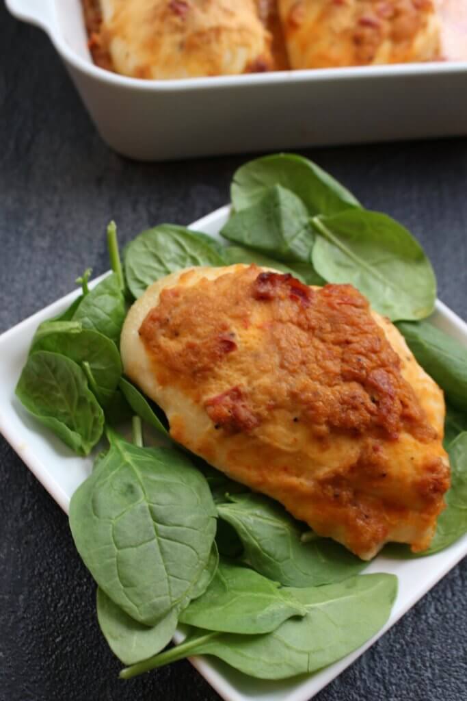 A simple chicken breast gets topped with creamy hummus for one weeknight meal that’s ready in no time! Sometimes I come up with a new meal idea and think to myself, “man, I still got it!” Just when I think my children have taken all my brain cells and zest for cooking with their hot dog and grilled cheese demands, I put two and two together like this hummus baked chicken and alas, mealtime is FUN again. Really though, whenever I serve chicken, steak, pork, etc. to the boys, I almost always serve it with hummus. Why? Because they dip almost anything in hummus. And I’m therefore almost guaranteed they’ll take a bit or two of the meat. So when my creative side decided it was time to TOP the chicken with hummus AND let the boys see what I was doing with their favorite spread [or dip], we were all pretty excited for the hummus baked chicken results! For this recipe I had Sabra Roasted Red Pepper hummus on hand so I decided to use that for the topping. Next time I think I’m going to try plain hummus + a tablespoon of dry ranch seasoning. Or maybe chipotle hummus + taco seasoning mix. Because there are so many flavors of hummus to choose from, the flavor combinations are endless!!! Needless to say, everyone enjoyed this simple meal that took less than 5 minutes to prep and dirtied one baking dish. My wheels are turning guys… what else besides chicken can I top with hummus and bake?!