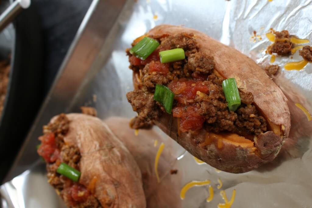 Taco stuffed sweet potatoes combine your favorite taco toppings with a nutritious sweet potato as a healthy base! Make this meal even quicker by cooking the sweet potatoes ahead of time. When it comes to weekly meal planning, we almost always have a taco-esc themed dinner night. So, whether that’s oven baked tacos, taco salads, or taco stuffed sweet potatoes, I’m bringing out the lean Ground Beef, some taco seasoning, and lots of cheese. Because the boys will demand cheese melted on a mini-tortilla when they realize it’s taco night! If you haven’t already guessed it, these taco stuffed sweet potatoes were thoroughly enjoyed by Ted and I. The boys? Eh. Like I said, they wanted cheese melted on a tortilla [in the microwave--- so gourmet!]. Anthony had some of the beef and a few bites of my sweet potato. Joey? He definitely had his fair share of melted cheese. That doesn’t mean your two or three-year-old won’t like taco stuffed sweet potatoes. I’m just giving you a heads-up to have some tortillas on hand for those that want carbs from a tortilla vs. a sweet potato. Can you blame them?! 