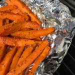 Sweet potato fries in foil in a grill.