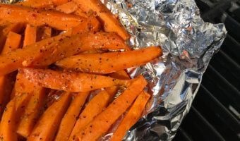 Sweet potato fries in foil in a grill.