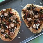Sausage, Pepper, and Onion Flatbreads are as simple as they sound. Let your slow cooker do the work for the sausage, and the mixture of hummus and feta cheese serve as the base for these flatbreads.