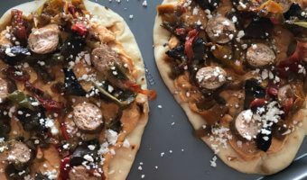 Sausage, Pepper, and Onion Flatbreads are as simple as they sound. Let your slow cooker do the work for the sausage, and the mixture of hummus and feta cheese serve as the base for these flatbreads.