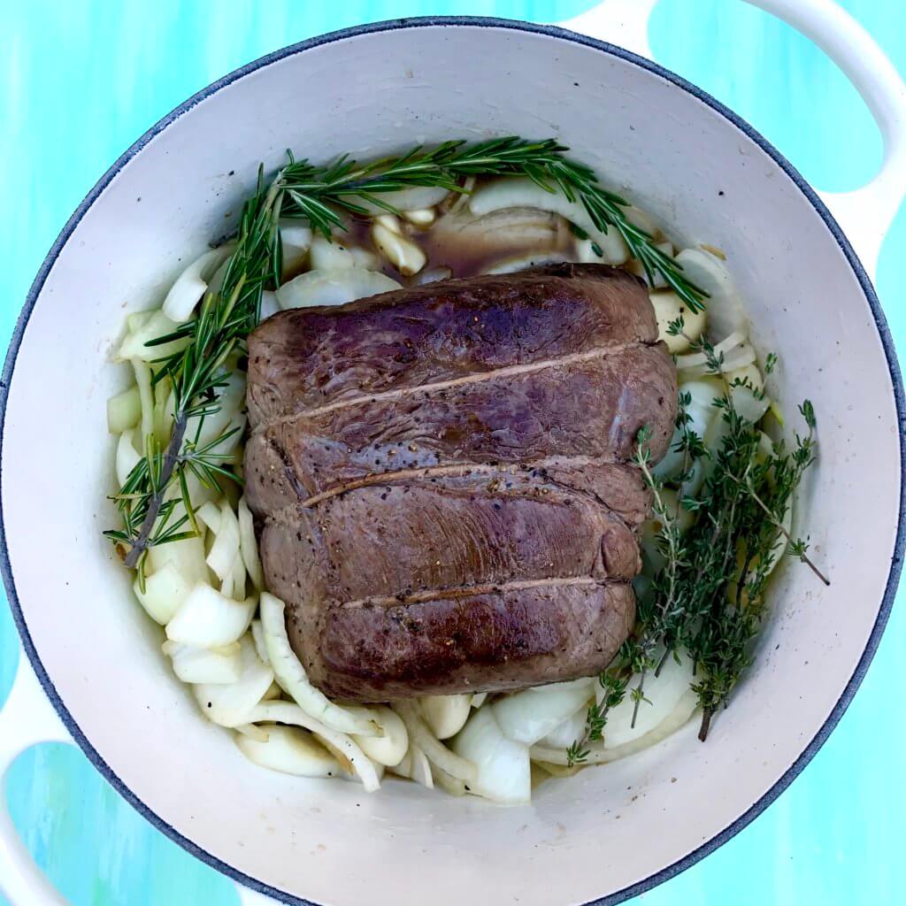 40-cloves-garlic-beef-roast-1 - Mom to Mom Nutrition 40 cloves of garlic beef roast whole on a white plate.