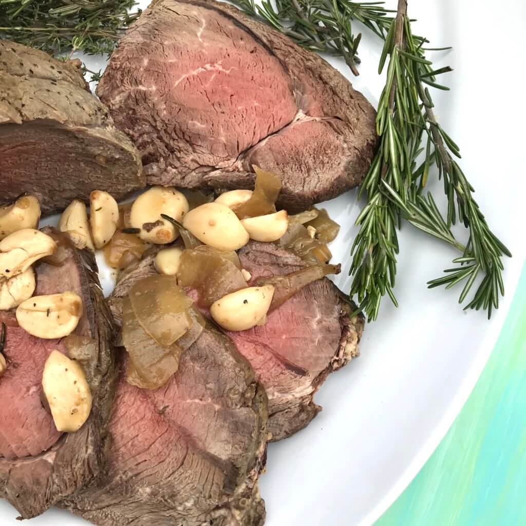 40-cloves-garlic-beef-roast-4 - Mom to Mom Nutrition 40 cloves of garlic beef roast sliced on a white plate.