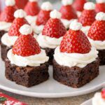 Santa hat brownie bites made with chocolate brownies, whipped cream, and strawberries