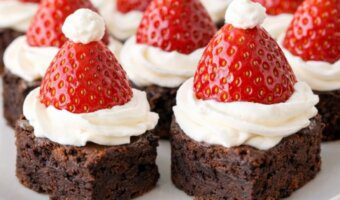 Santa hat brownie bites made with chocolate brownies, whipped cream, and strawberries